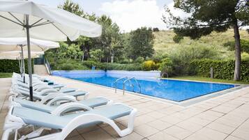 Alberca al aire libre por temporada y sombrillas en la alberca