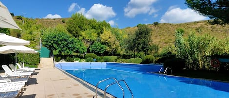 Seasonal outdoor pool, open 9:00 AM to 9:00 PM, pool umbrellas