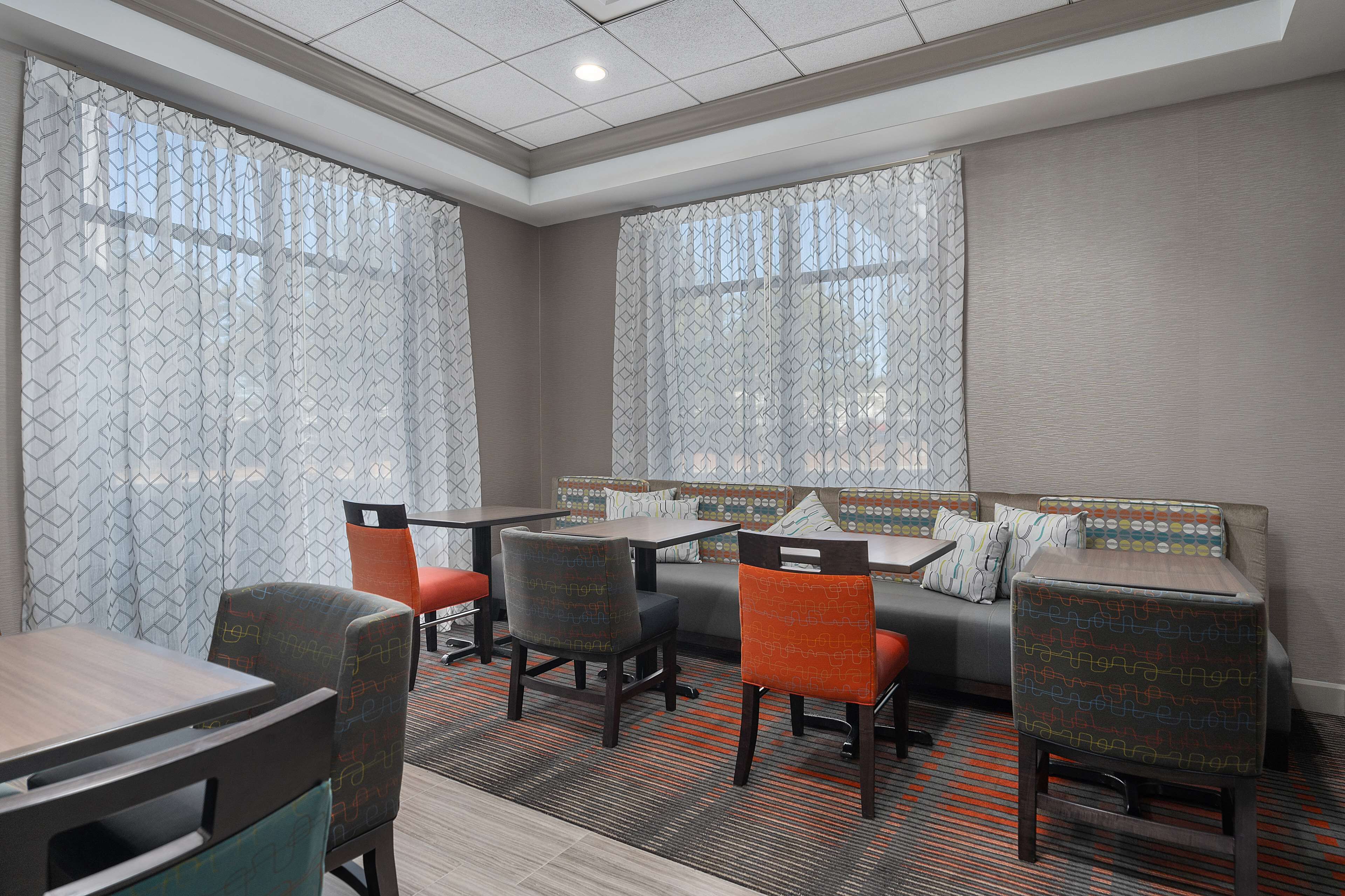 Habitación de hotel con zona de comedor, que incluye una mesa, sillas y un sofá.