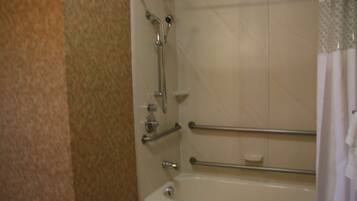 Un baño con bañera, ducha y retrete. Se instalaron barras de apoyo para mayor seguridad.