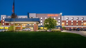 A Hampton Inn hotel with a modern design, featuring a flat roof, brick facade, and a well-lit entrance.