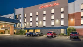 A Hampton Inn hotel with a modern facade, multiple parking spaces, and a welcoming entrance.