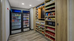 Zona de venta automática de refrigerios y bebidas con dos refrigeradores, uno etiquetado 'frío' y el otro 'congelado'.