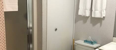 A bathroom with a shower, toilet, and sink.