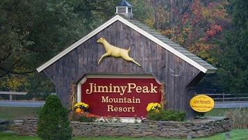 Un edificio de madera con un letrero que dice "JiminyPeak Mountain Resort".