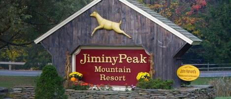 Un edificio de madera con un letrero que dice "JiminyPeak Mountain Resort".