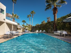 A clear blue pool with lounge chairs and umbrellas, surrounded by palm trees and a modern building. - Movie Colony Hotel - Adults Only (Palm Springs)