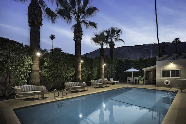 Una piscina al aire libre, sillones reclinables de piscina