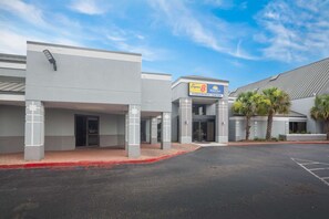 A modern building with a sign for 'Super 8 Conference Center' and a parking lot.