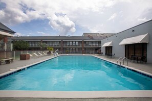 Piscine extérieure en saison, chaises longues