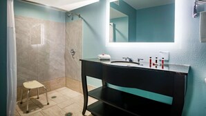 A modern bathroom with a black vanity, a large mirror, and a shower area. - Super 8 by Wyndham Mobile I-65 (Mobile)
