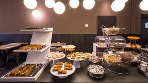 A buffet setup with various food items and a seating area. - Hotel Ariston (Mestre)