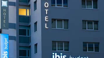 Um edifício de hotel com o nome "ibis budget" em destaque na fachada.
