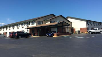 Un motel doté d’un parking couvert et d’un bâtiment comportant de nombreuses fenêtres et une antenne parabolique.