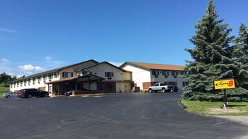 A motel with a parking lot, a covered entrance, and a sign for 'Super 8' hotel.