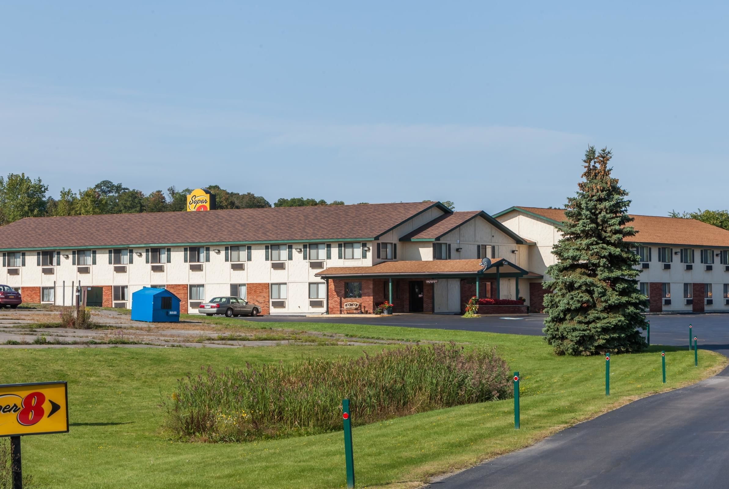 Un motel con un edificio centrale, una struttura blu e un albero di Natale.