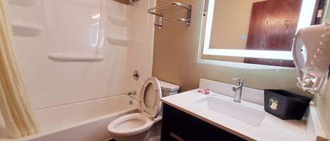 A bathroom with a bathtub, toilet, and sink.