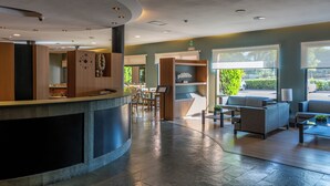 Un área de recepción con mostrador, asientos y vistas al exterior.