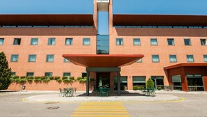 Un hotel con fachada de ladrillo rojo, una entrada central con toldo y un letrero que dice "Posadas de España".