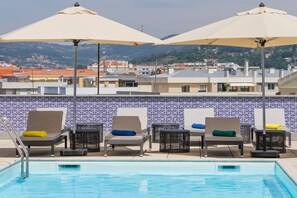Una piscina al aire libre de temporada, sombrillas
