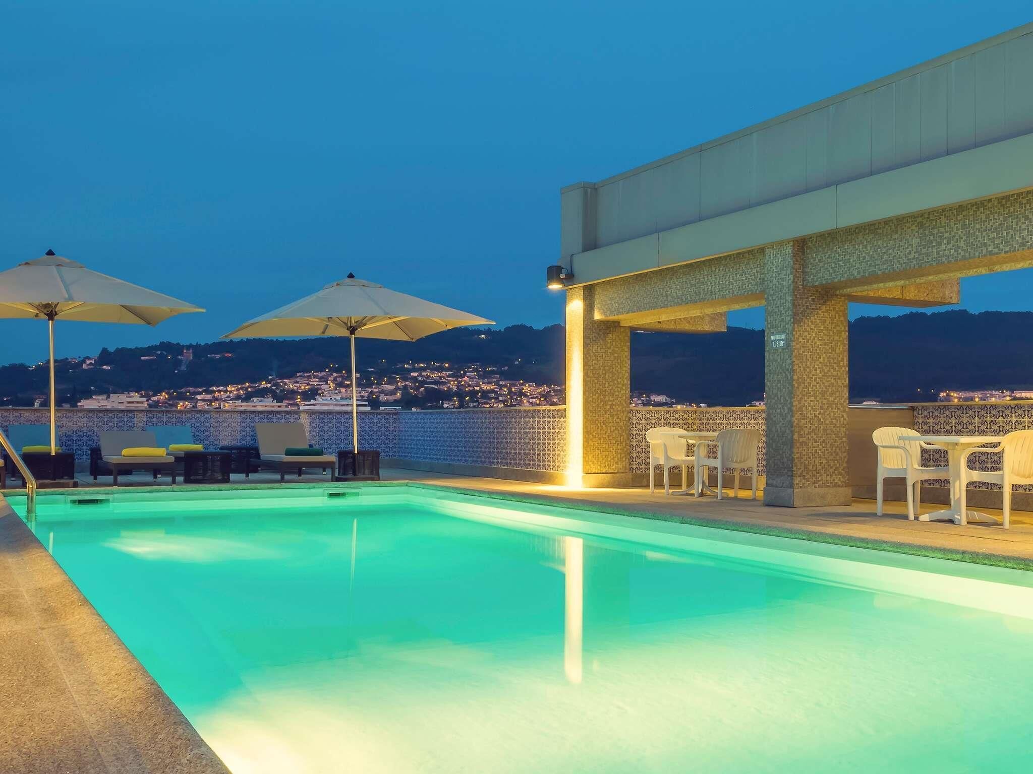 Una piscina al aire libre de temporada, sombrillas