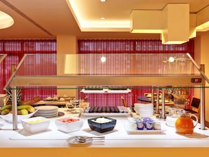 A buffet setup with various food items and a digital clock displaying 6:33. - Mercure Braga Centro (Braga)
