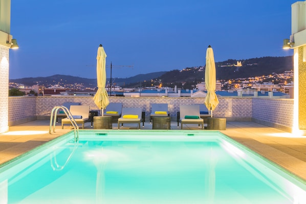 Piscine extérieure en saison, parasols, chaises longues