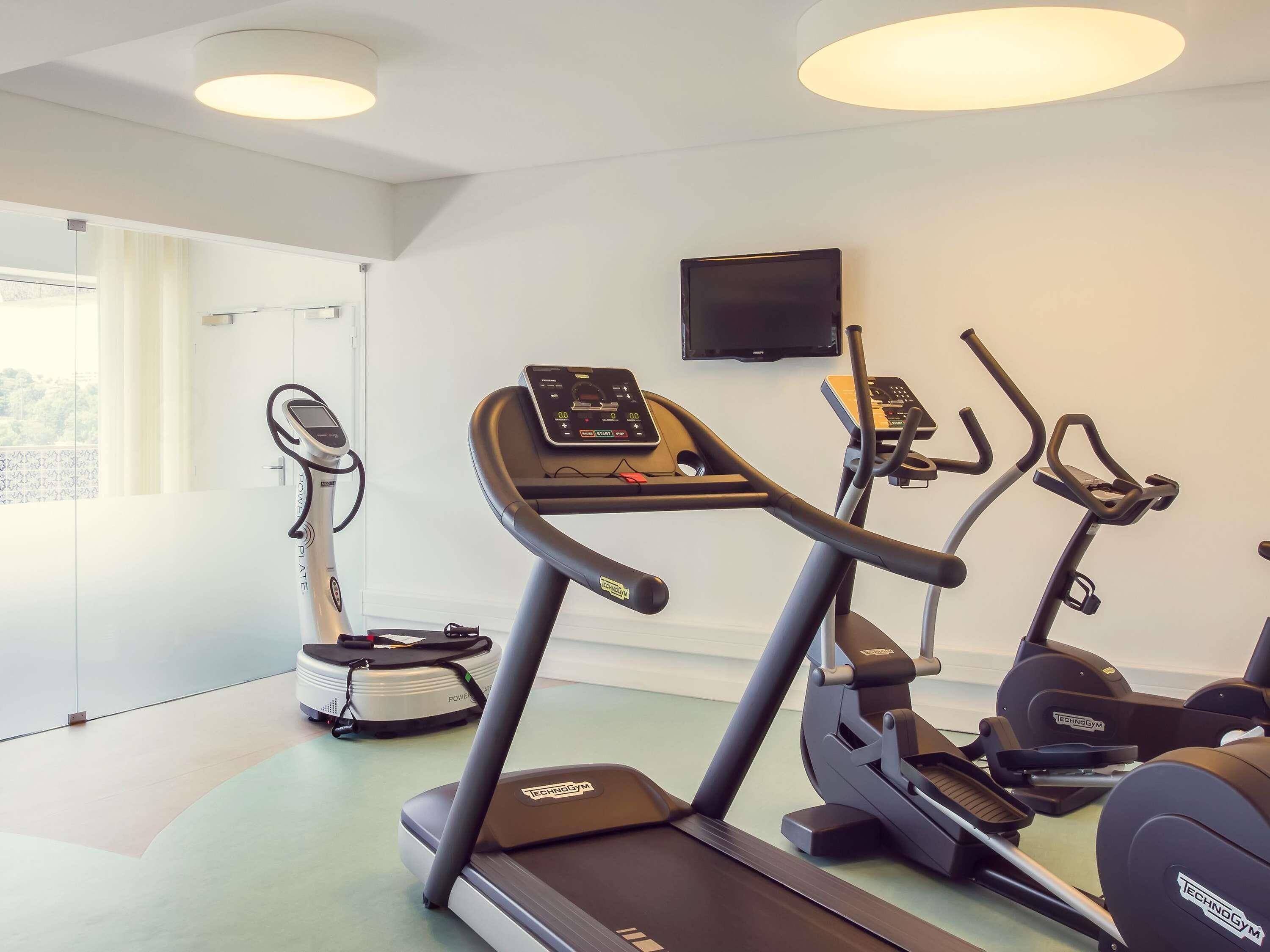 A gym with treadmills, a rowing machine, and a stationary bike.