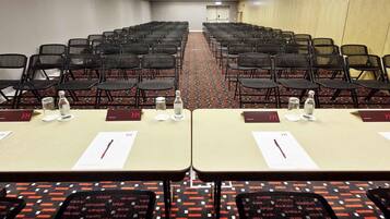 A conference room with rows of chairs and tables, each with a nameplate and water bottle.