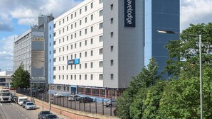 Un hotel Travelodge con un diseño moderno, con varios pisos y un letrero grande de Travelodge.