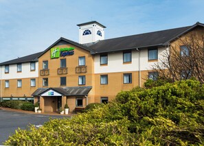 A hotel with a prominent Express sign, multiple windows, and a central tower. - Holiday Inn Express Swansea - East by IHG (Neath)