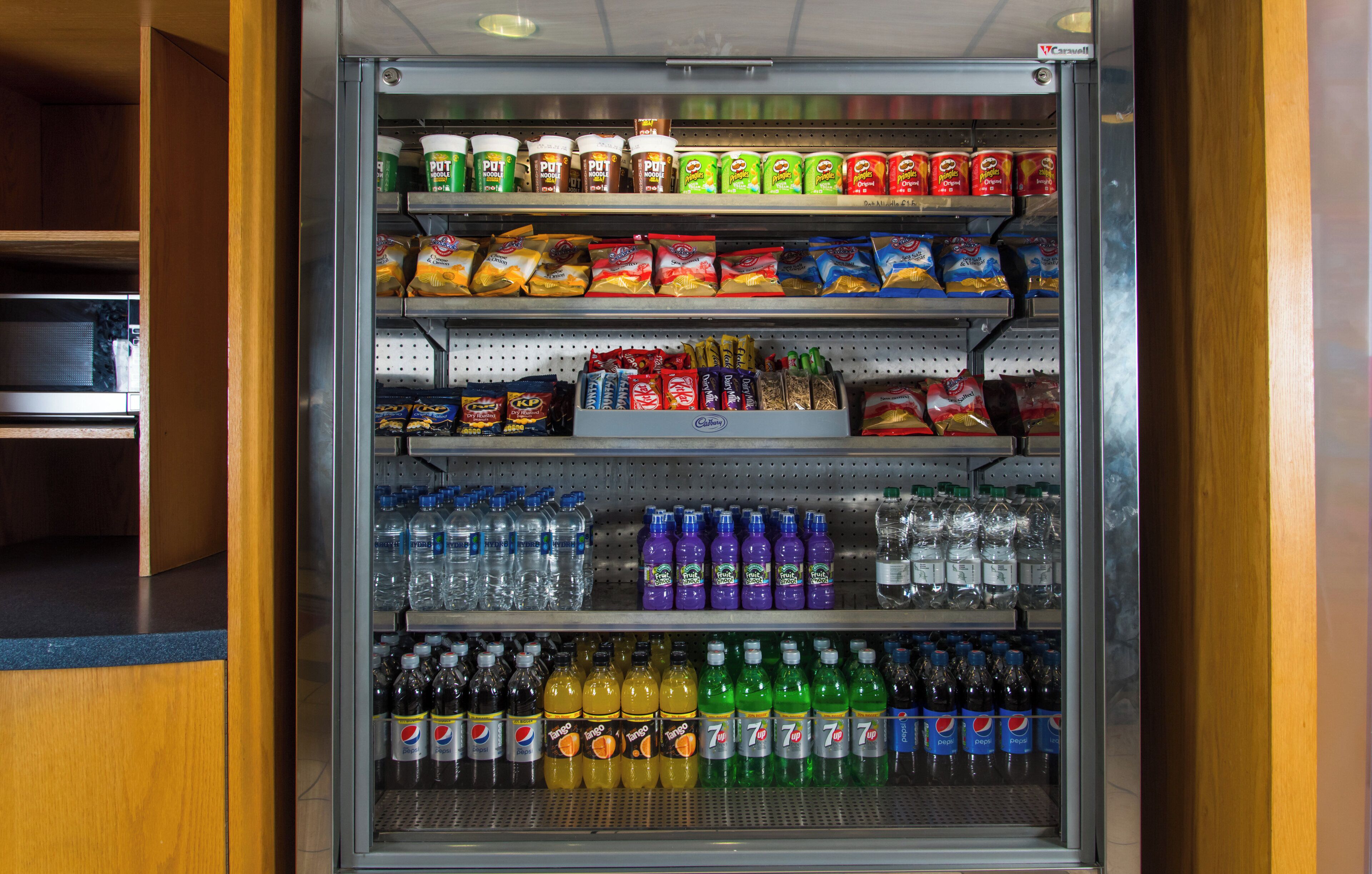 A vending machine stocked with various snacks, bottled water, and soft drinks.