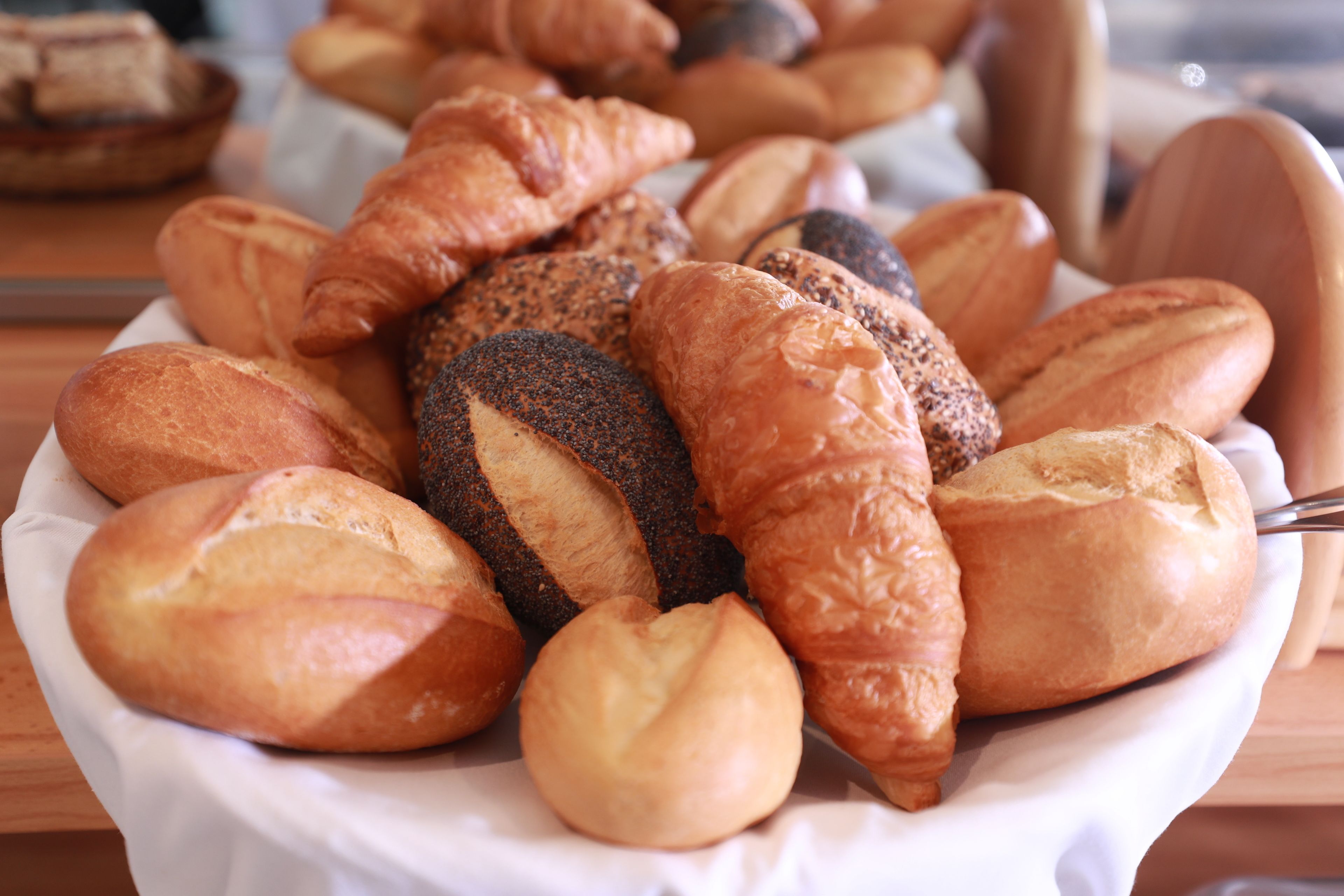 A variety of breads and pastries on a white plate.