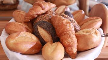 A variety of breads and pastries on a white plate.