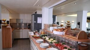 A buffet area with various food items, plates, and a coffee station. - Hotel Savoy Bonn (Bonn)