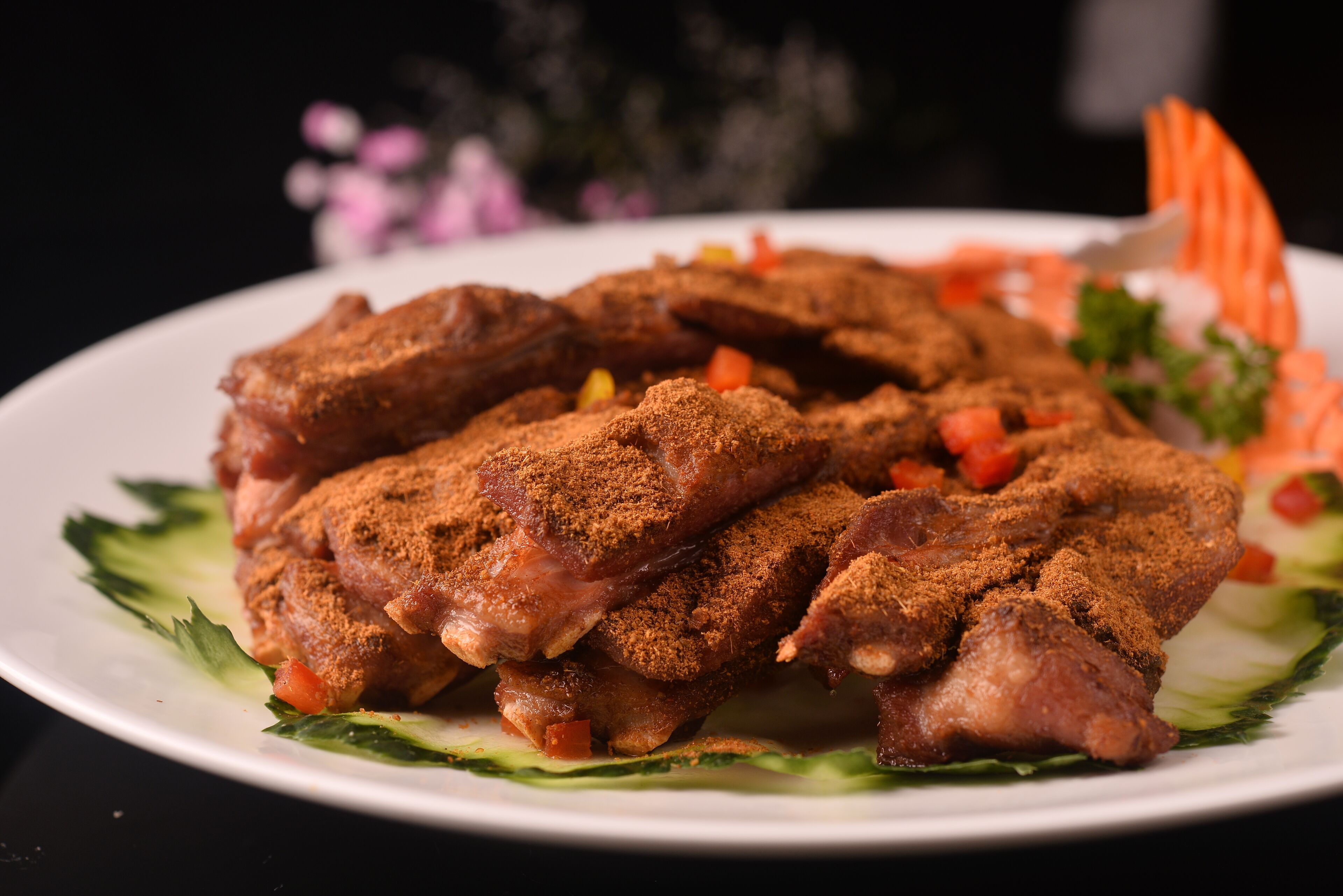 A plate of seasoned meat with vegetables.