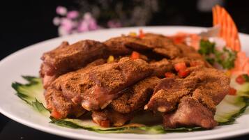 A plate of seasoned meat with vegetables.