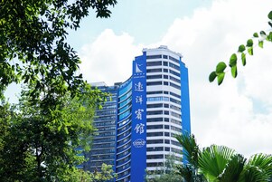 Ein Hochhaus-Hotel mit blauer Fassade, mehreren Etagen und einem markanten Logo.