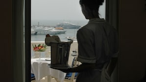 A room with a view of a port, a table with a fruit bowl, and a metal container. - Hotel Splendid Cannes (Cannes)