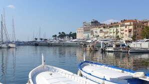 A marina with various boats docked, surrounded by buildings with balconies. - Hotel Splendid Cannes (Cannes)