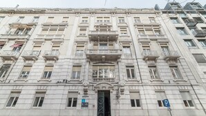 A large, historic building with a symmetrical facade, multiple balconies, and a central entrance with a decorative arch. - Hotel Dom Sancho I (Lisbon)