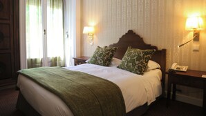A hotel room with a large bed, two bedside lamps, a nightstand, and a telephone. - Hotel Dom Sancho I (Lisbon)