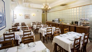 A dining area with multiple tables set for service, a bar area, and a decorative ceiling. - Hotel Dom Sancho I (Lisbon)