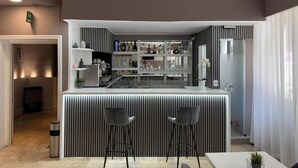 A modern kitchen with a central island, bar stools, and a dining area.
