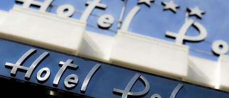 A hotel sign with the name "Hotel Polo" and decorative stars above the letters.