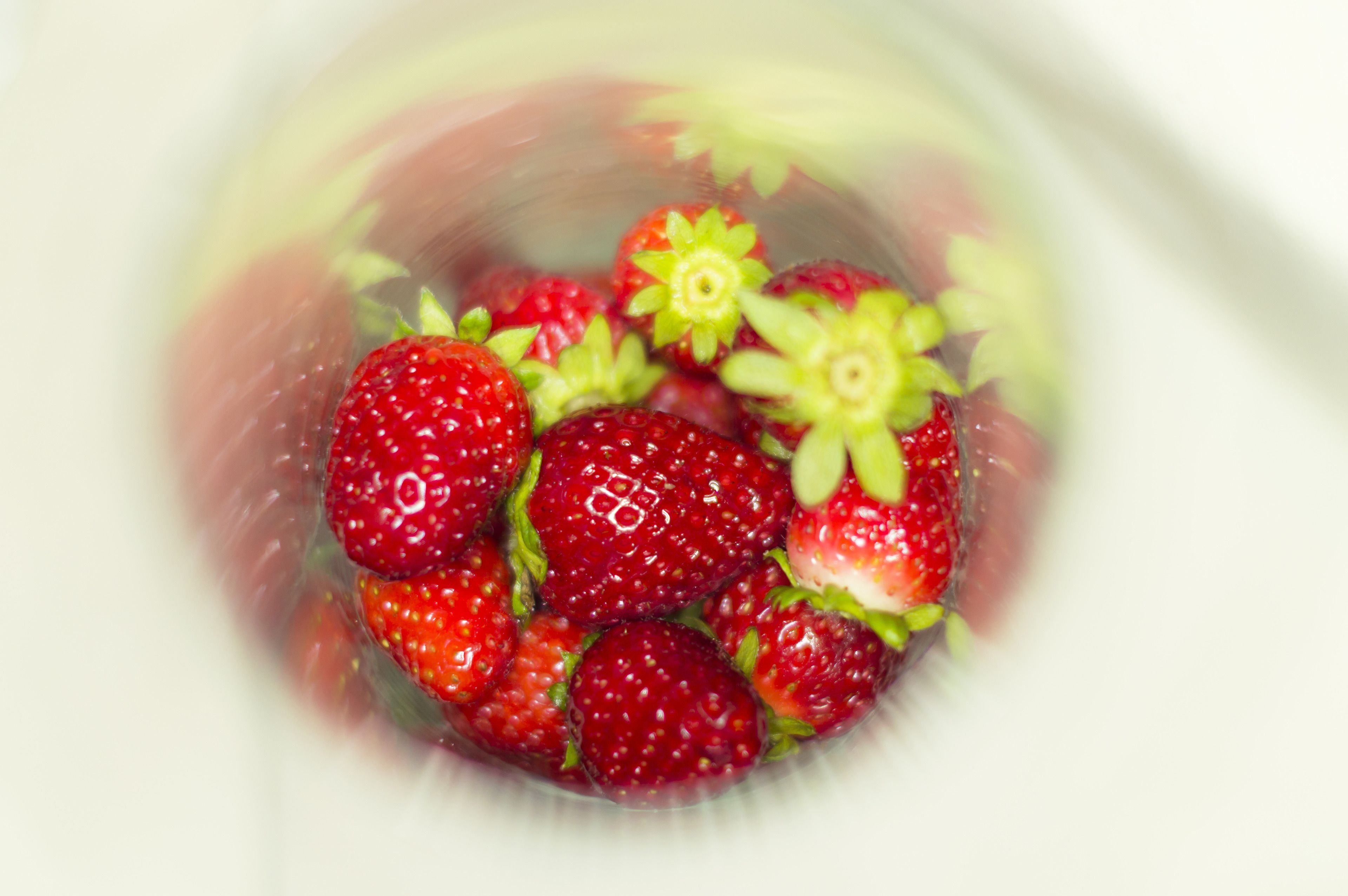 A close-up of strawberries in a transparent container.