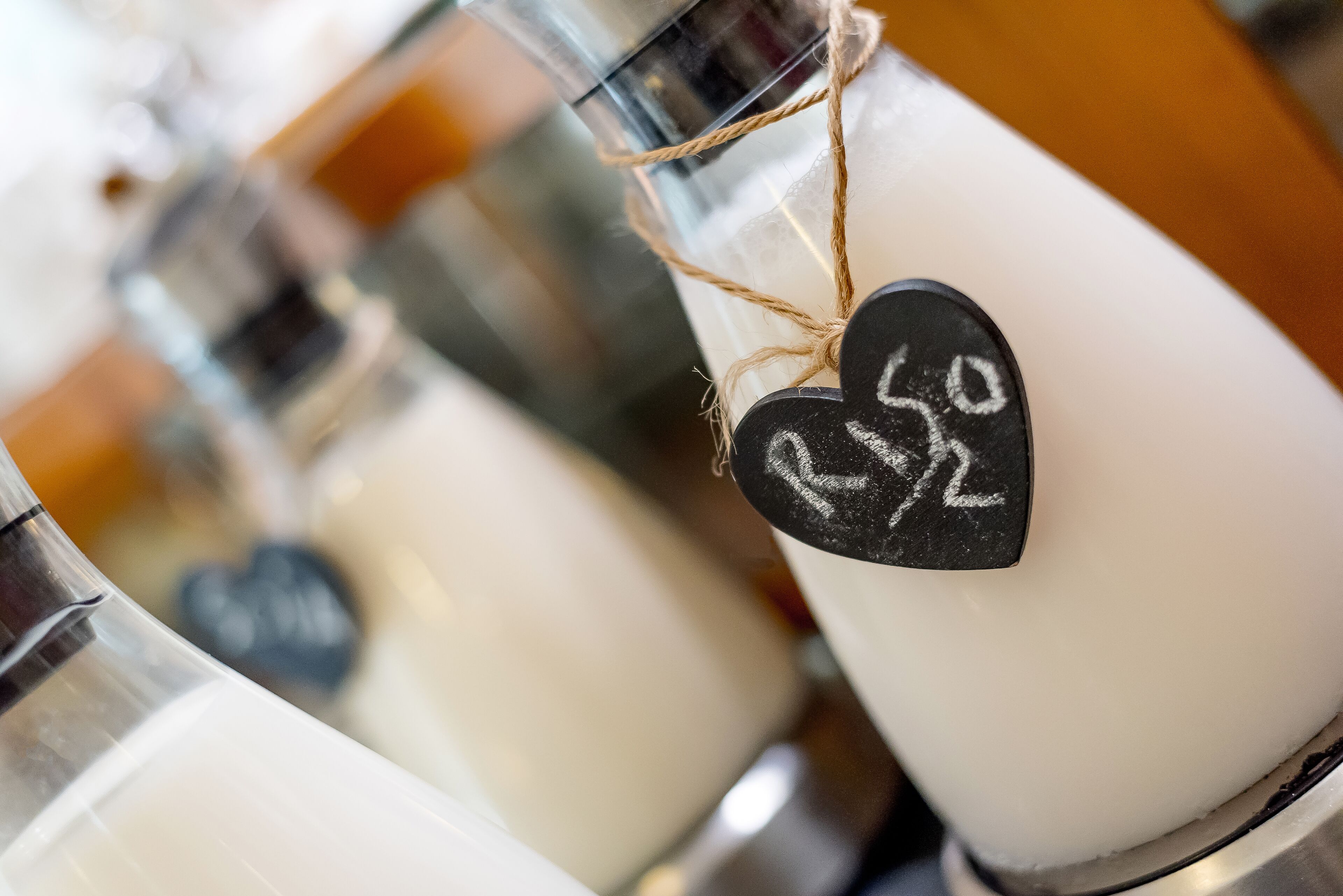 Primer plano de un candelabro blanco con una etiqueta en forma de corazón sujeta con un hilo.