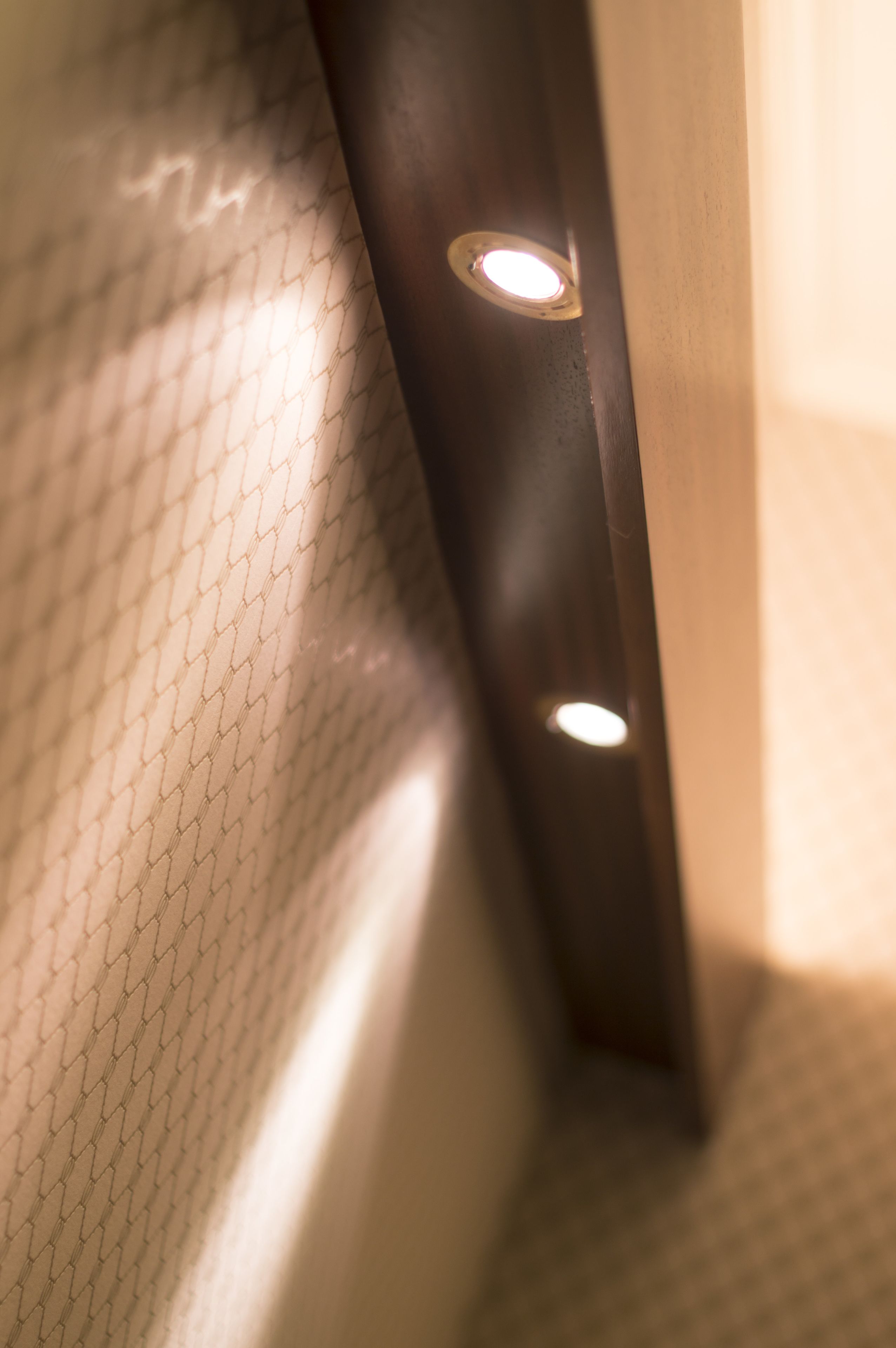 Et nærbillede af en væg med struktur og en indbygget loftlampe.