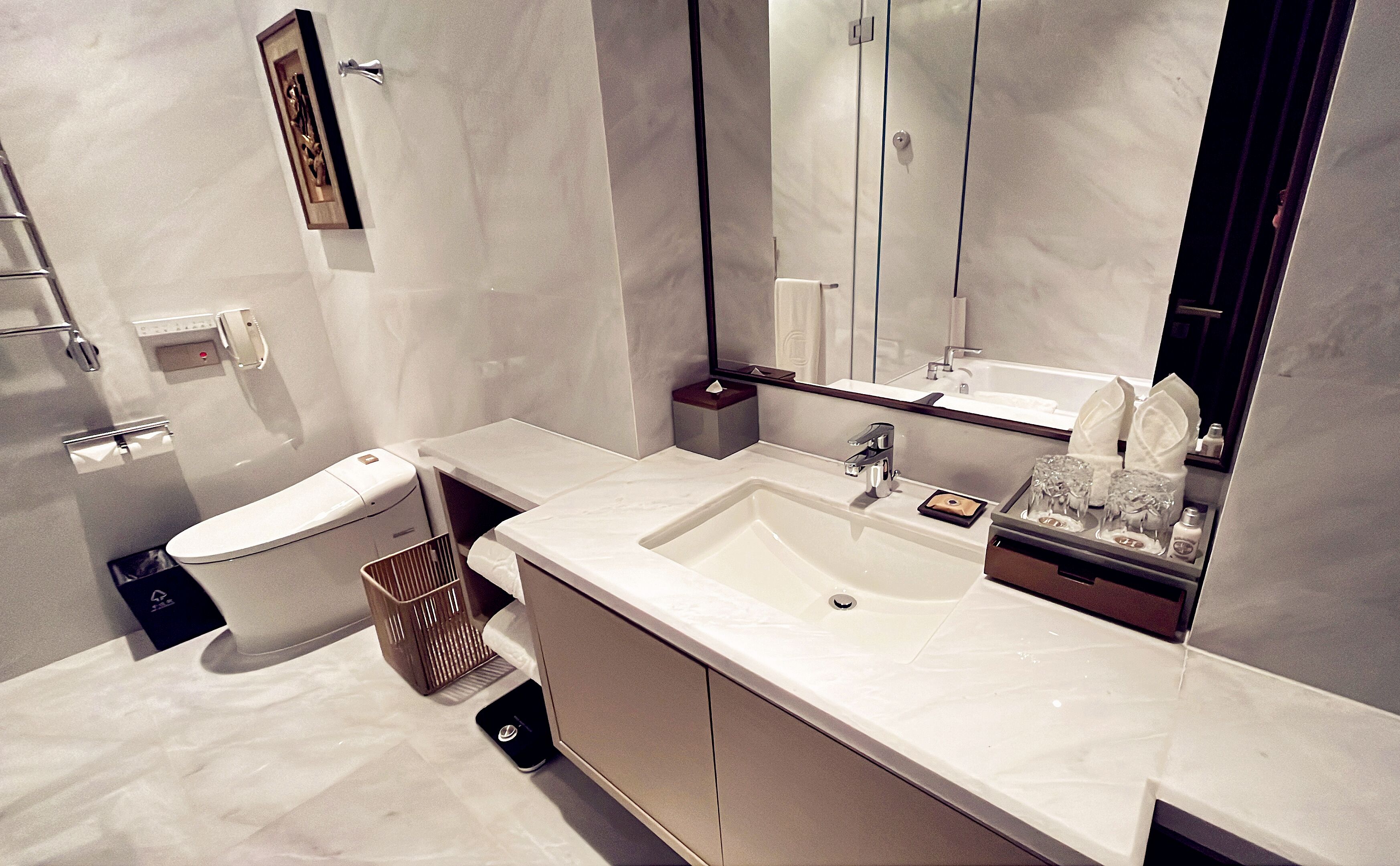 Une salle de bain moderne avec un lavabo blanc, un miroir et des toilettes.