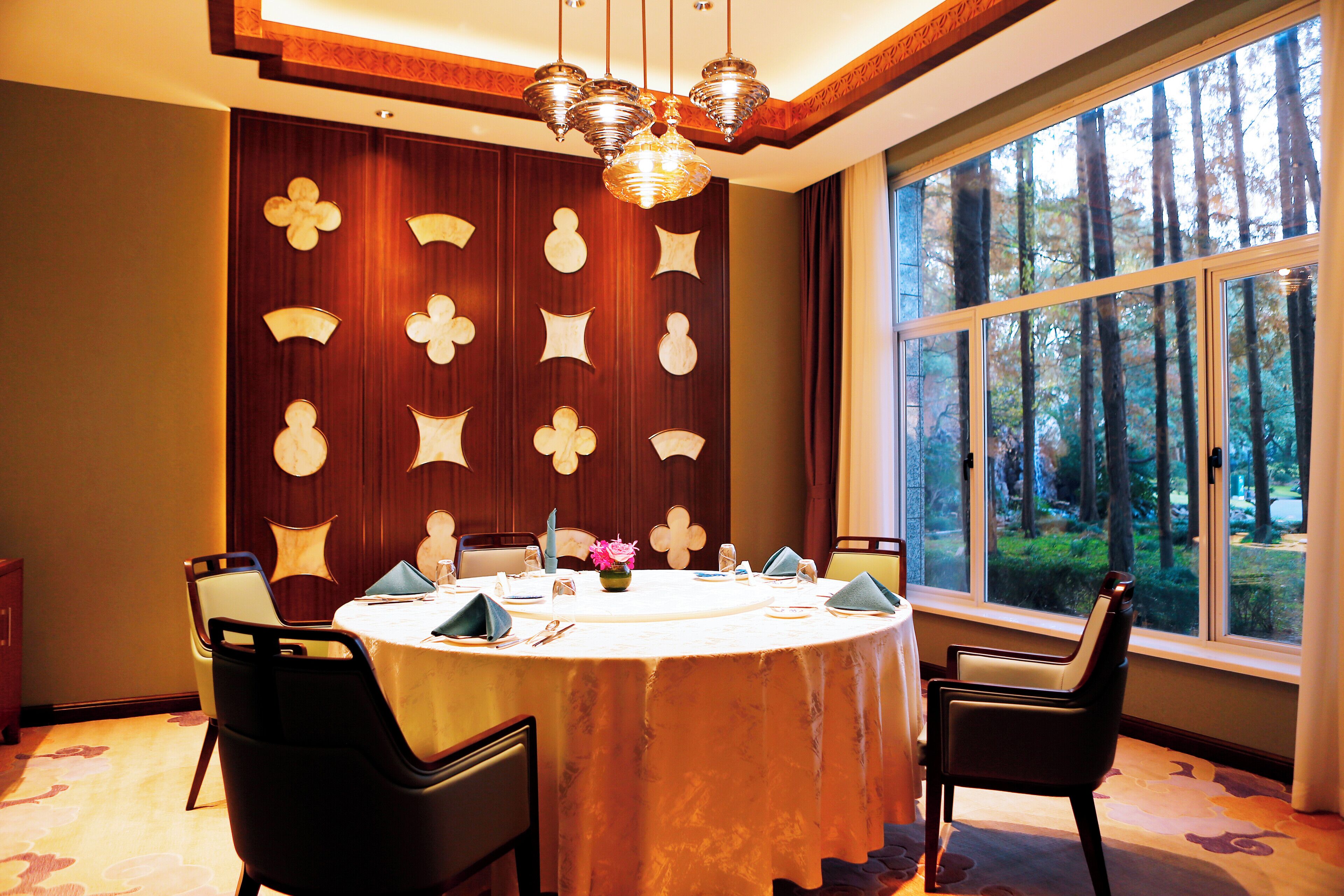 A dining area with a round table, chairs, and a decorative wall with geometric patterns.